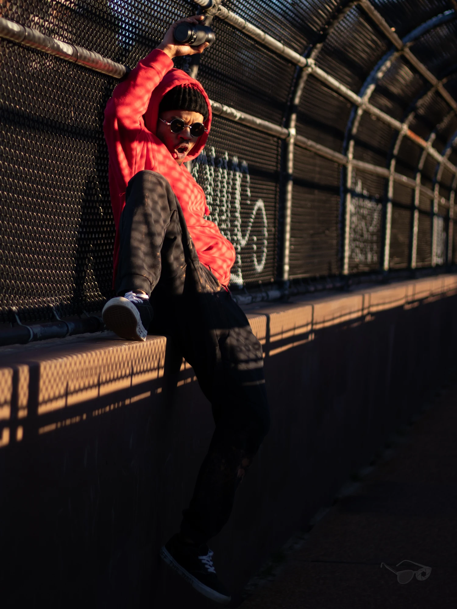 Self Portrait by Zian: a figure in red in a sunlit covered walkway
